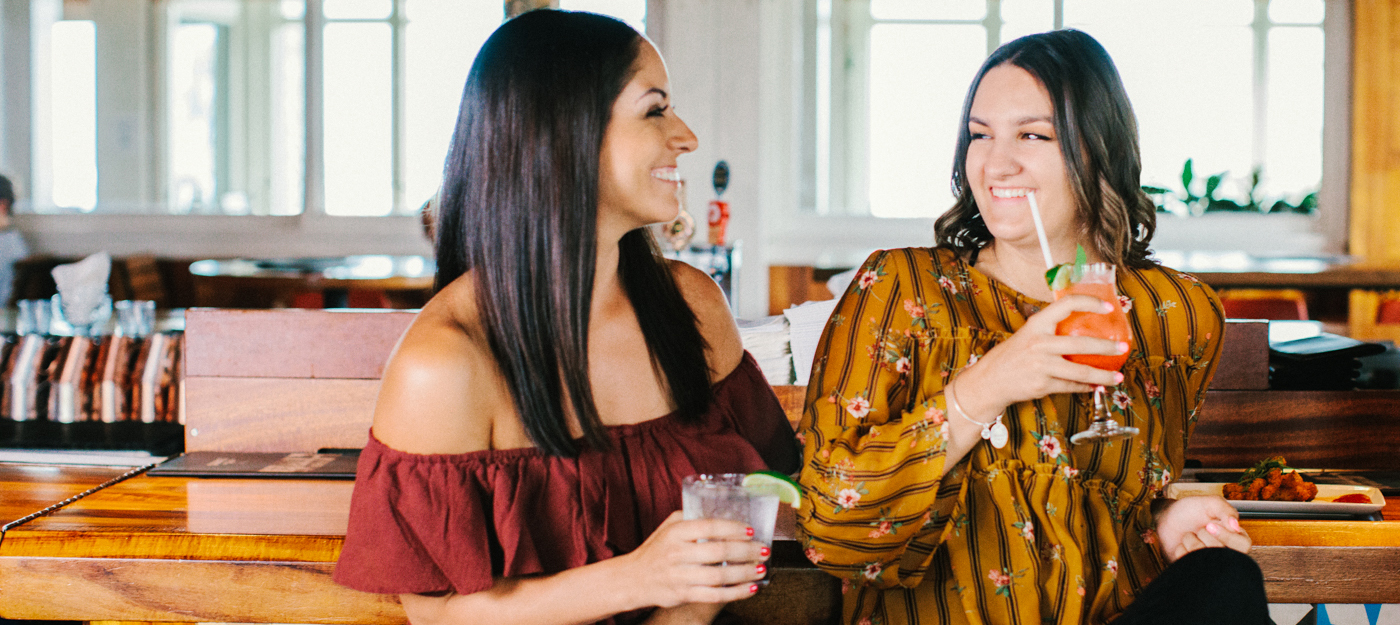 Two women sharing a cocktail together