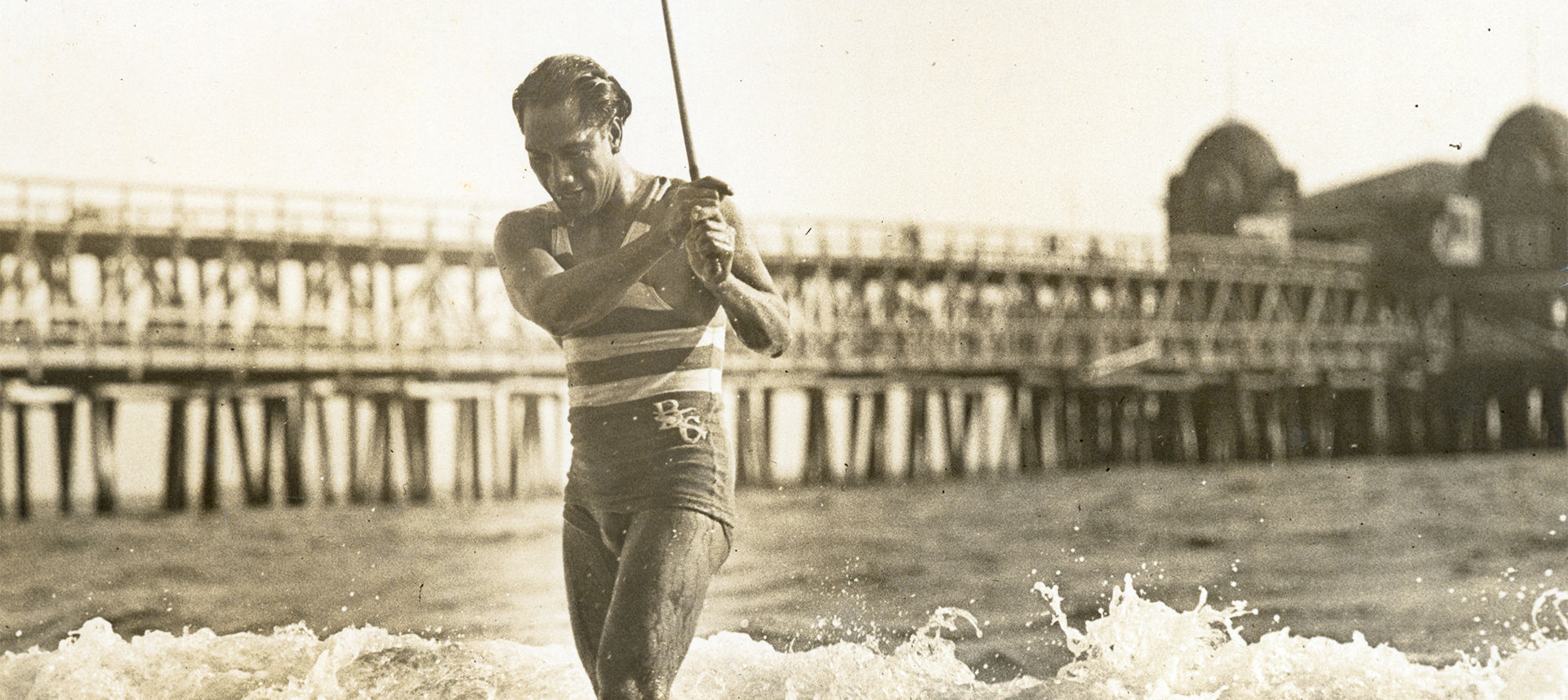 Duke exiting the ocean with stick in hand