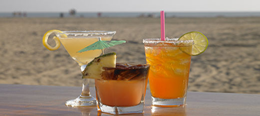 Three cocktails with the beach in the background