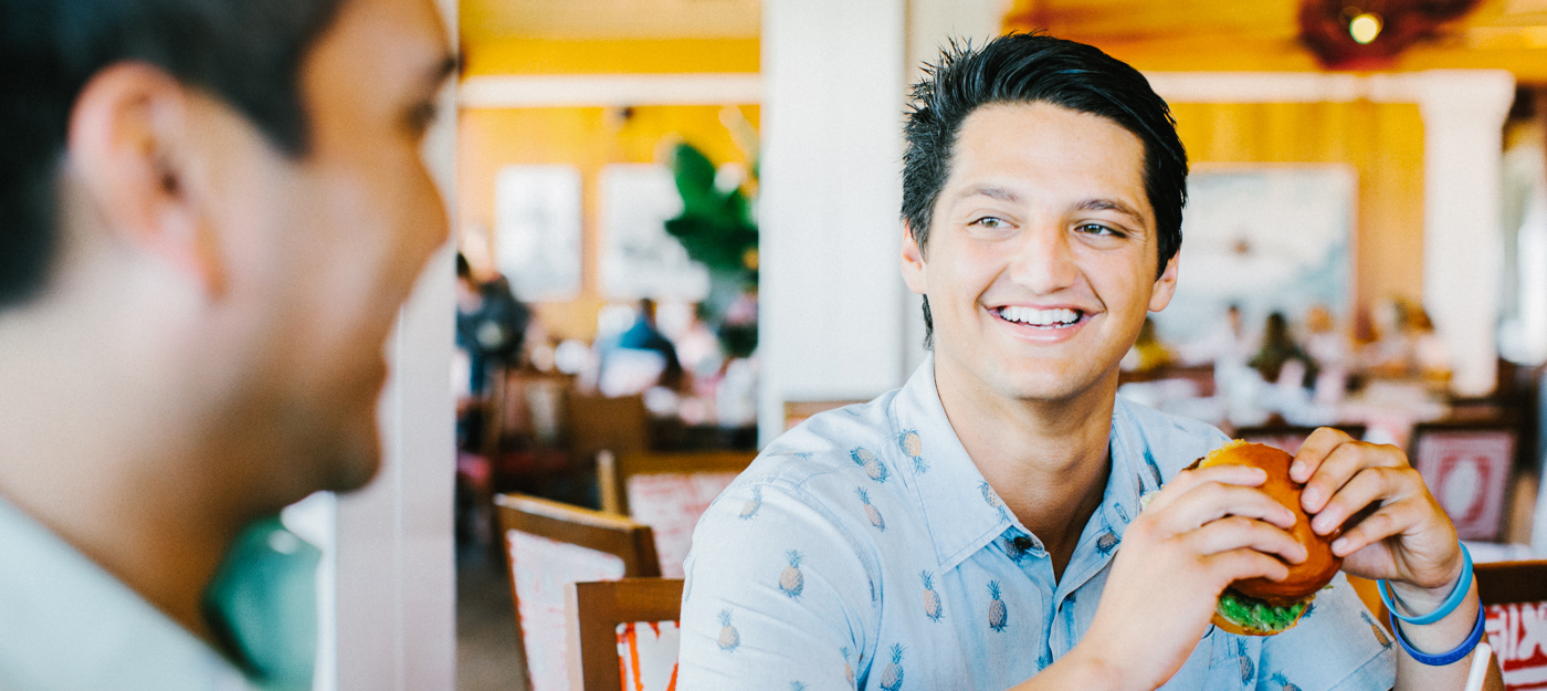 Two men sharing laughs over a meal